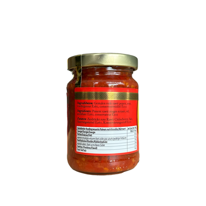 Scharfe rote Sambal Rawit Merah von Vanka Kawat, würzige Chilisauce in Glasflasche, frische rote Chilis sichtbar.